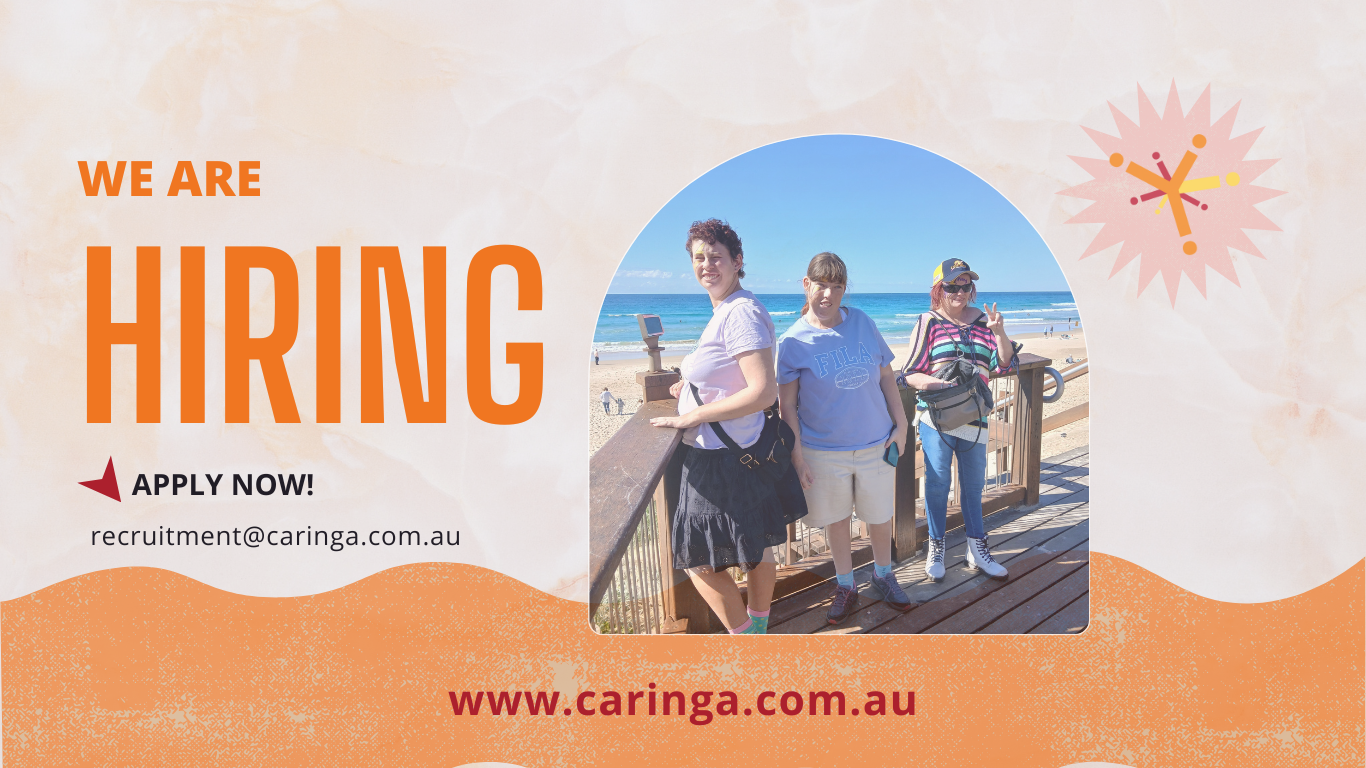 A job announcement titled "WE ARE HIRING" in large orange text. It includes the call to action, "APPLY NOW!" followed by the email: "recruitment@caringa.com.au." A circular photo shows three women smiling and posing on a boardwalk near a beach. The clear blue sky and ocean are visible in the background. The bottom also features a website link: "www.caringa.com.au." The design has beige and orange tones, with a cheerful starburst graphic in the corner.